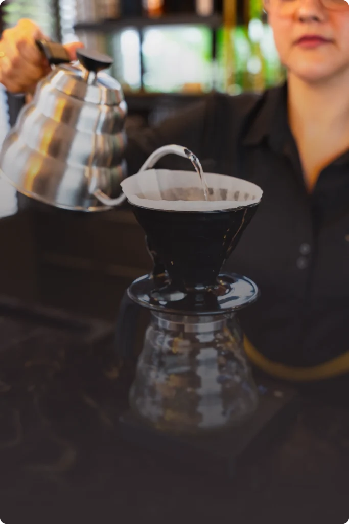 Preparo de café coado com chaleira de bico fino no Veneto Bistrô.