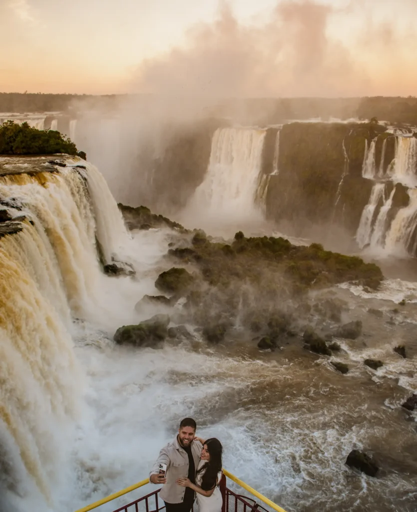 Casal sorrindo nas Cataratas do Iguaçu.