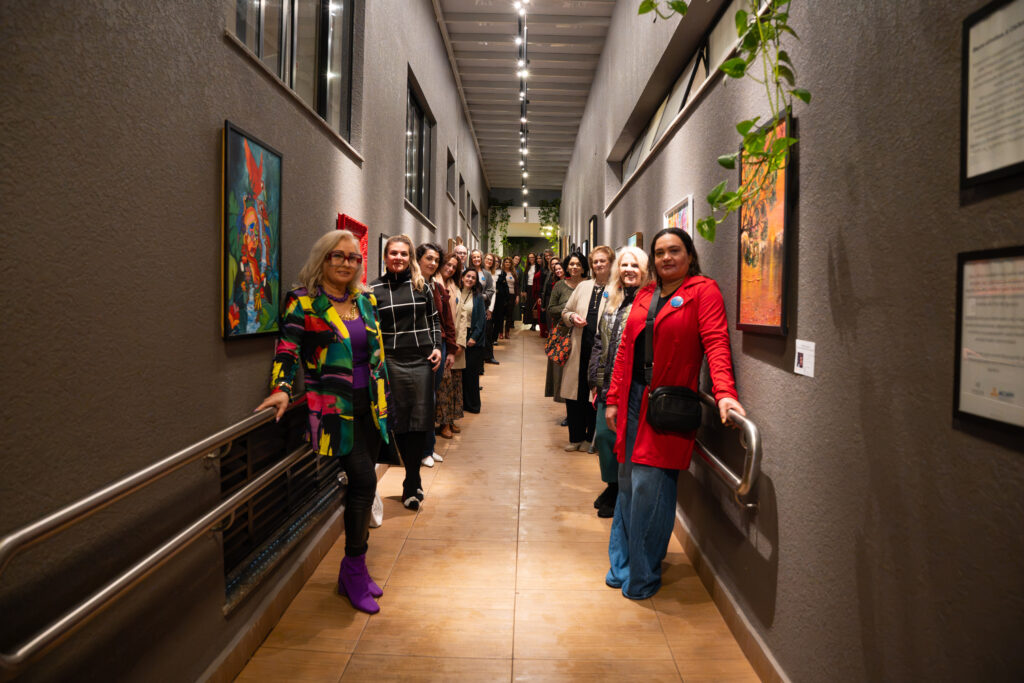 Grupo de mulheres em corredor decorado.