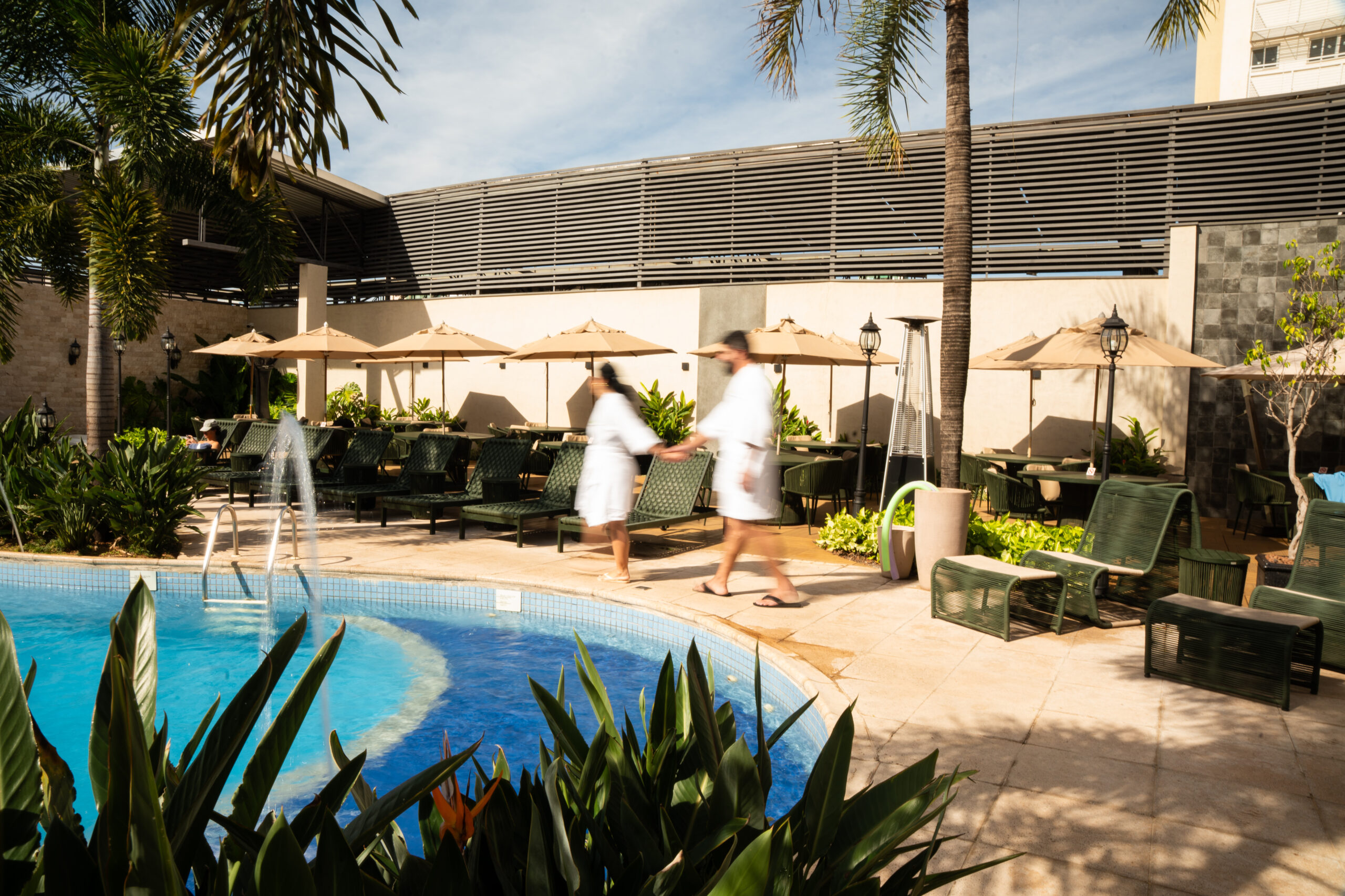 Pessoas em roupões perto da piscina