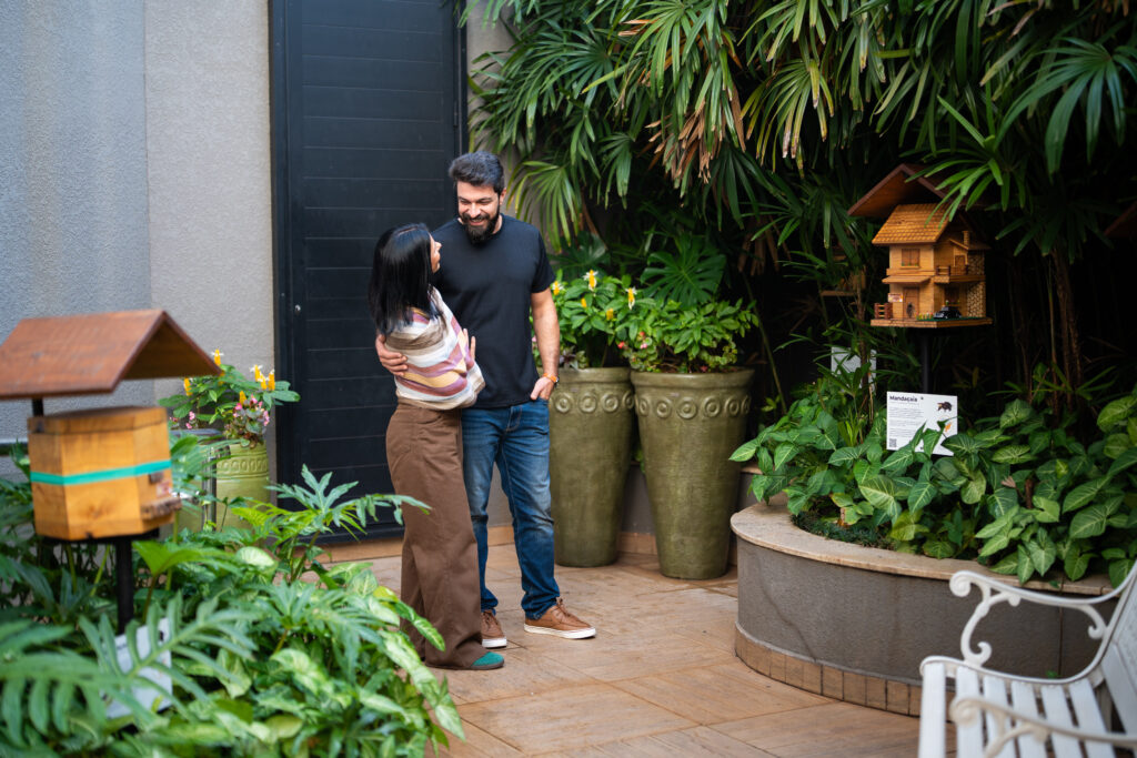 Arte, cultura e raízes locais: o Nadai é ponto de encontro entre hospitalidade e identidade 4 Casal sorridente em ambiente natural, no Meliponário do Hotel Nadai.