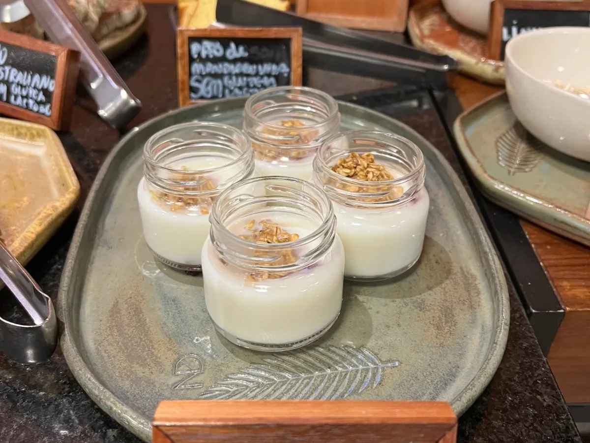 Experiências 5 Mesa de café da manhã com potes de vidro e placa escrita: mingau zero lactose.