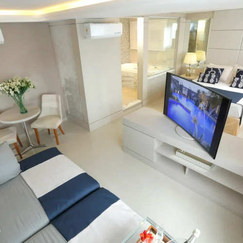 Acomodações 2 visão panorâmica mostrando TV, sofá e outros itens presente na suíte master.